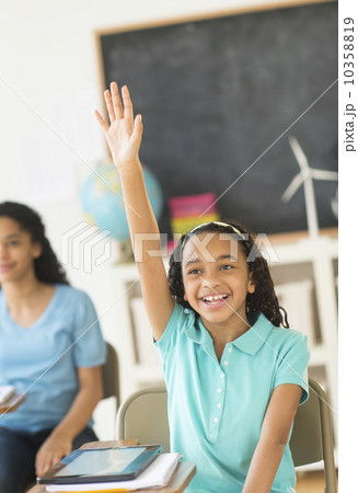 Schoolgirl (10-13) raising hand 10358819