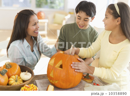 Mother with son (12-13) and daughter (10-11) doing Jack o lantern Mother with son (12-13) and daughter (10-11) doing Jack o lantern 10358890