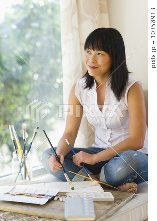 Mid adult woman painting at home 10358913