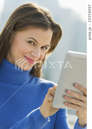 Woman using digital tablet outdoors Woman using digital tablet outdoors 10359097