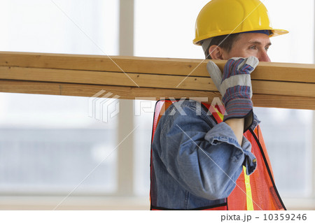 Construction worker carrying planks 10359246