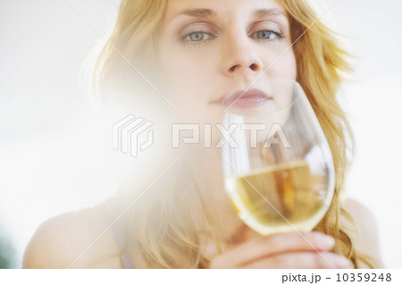 Portrait of young woman smelling wine, studio shot 10359248
