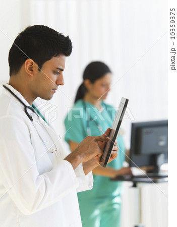 Doctors working on digital tablet and computer Doctors working on digital tablet and computer 10359375