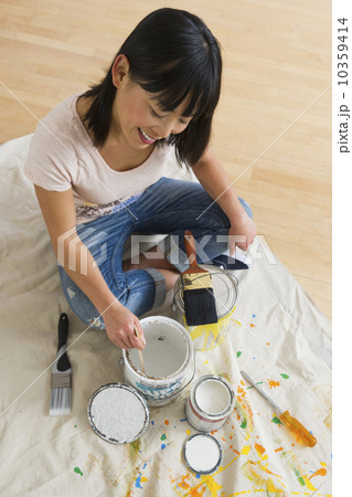 Smiling woman mixing paint Smiling woman mixing paint 10359414
