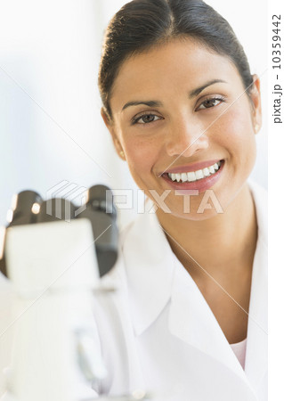 Female scientist looking through microscope 10359442