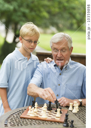 Grandfather teaching grandson (10-11) how to play chess Grandfather teaching grandson (10-11) how to play chess 10359898