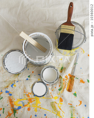 Paint cans and paintbrushes on drop cloth 10360012