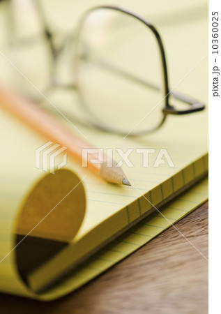 Close up of glasses, notebook and pencil, studio shot 10360025
