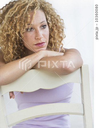 Portrait of young woman leaning on chair 10360080
