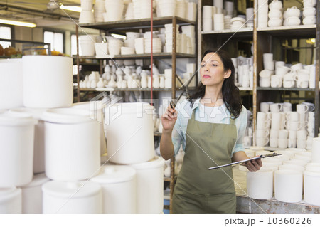 Woman with checklist in pottery warehouse Woman with checklist in pottery warehouse 10360226