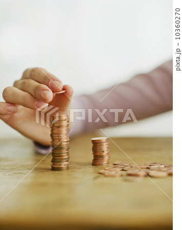 Woman's hand stacking coins, studio shot 10360270