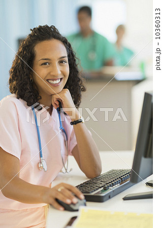 Portrait of smiling female doctor working at desks in hospital 10360313