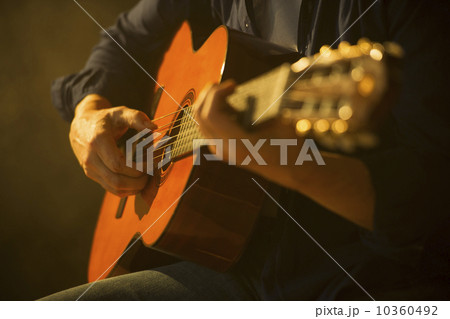 Close up of man playing acoustic guitar, studio shot Close up of man playing acoustic guitar, studio shot 10360492