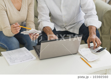 Couple using laptop and calculator 10360560