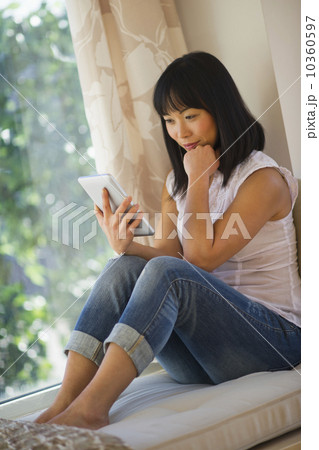Smiling mid adult woman using digital tablet 10360597