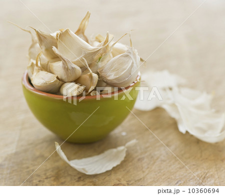 Studio shot of fresh garlic cloves in green bowl 10360694