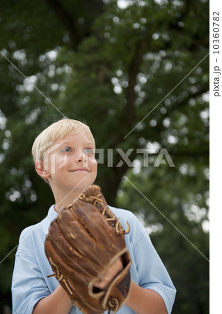 Boy (10-11) wearing baseball glove 10360782