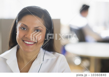 Businesswoman with headset, businessman in background 10360840