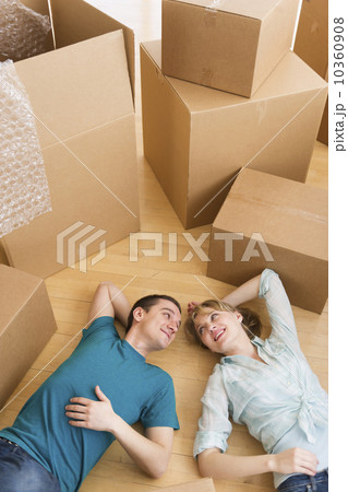 Couple lying among cardboard boxes during relocation Couple lying among cardboard boxes during relocation 10360908