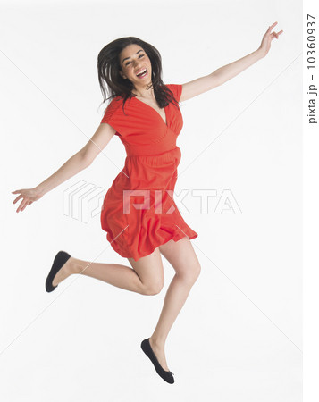 Studio portrait of young woman jumping 10360937
