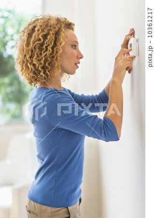 Young woman setting air conditioning 10361217