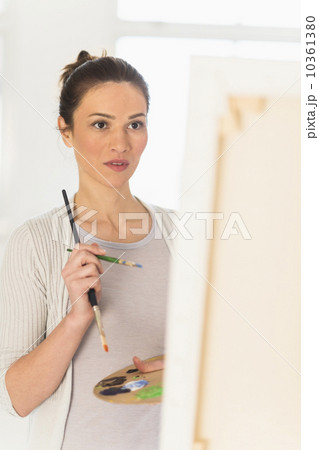 Woman painting at easel 10361380