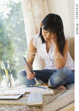 Mid adult woman painting at home 10361413
