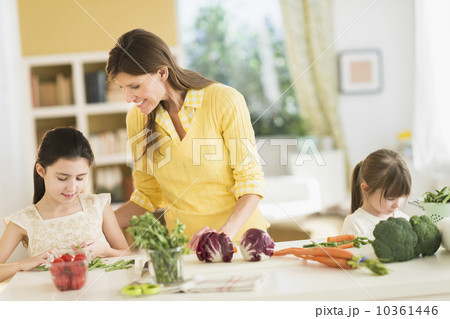 Mother and daughters (4-5,8-9) cooking in kitchen Mother and daughters (4-5,8-9) cooking in kitchen 10361446