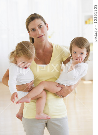 Mother holding daughters (2-3) and making facial expression 10361505