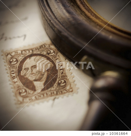 Studio shot of magnifying glass and old post stamp Studio shot of magnifying glass and old post stamp 10361664