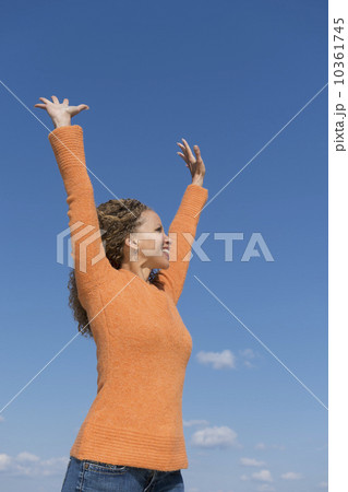 Mature woman with arms raised towards blue sky 10361745