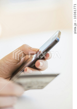 Close up of woman's hand doing online banking with mobile phone Close up of woman's hand doing online banking with mobile phone 10361771
