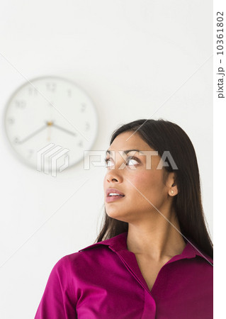 Woman looking at clock on wall 10361802