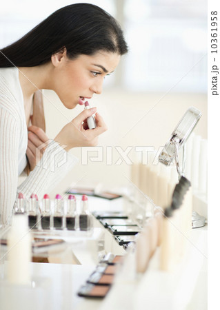 Young woman applying lipstick 10361958