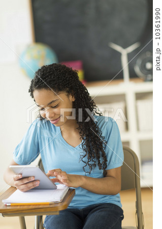 Schoolgirl (12-13) using tablet pc 10361990