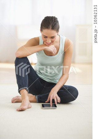 Woman sitting on floor and using digital tablet Woman sitting on floor and using digital tablet 10362131