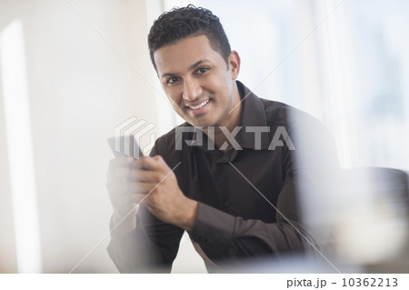 Businessman text messaging in office 10362213