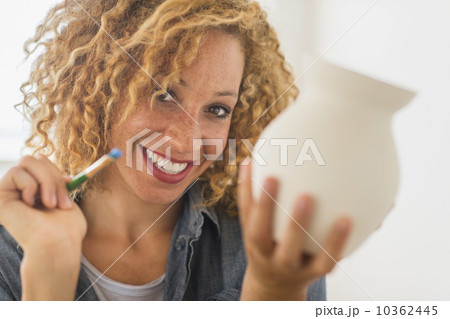 Portrait of female artist painting on ceramics in studio 10362445