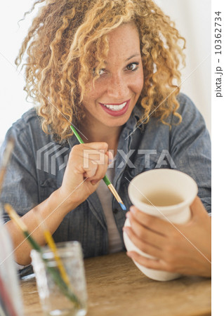 Portrait of female artist painting on ceramics in studio 10362734