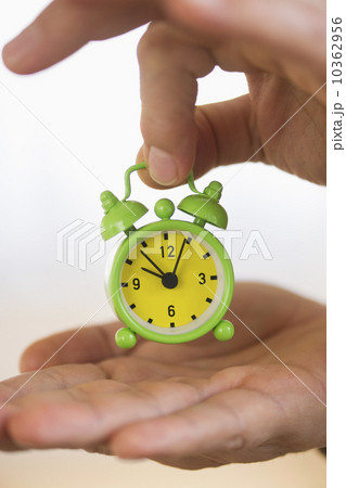 Close up of man's hand holding alarm clock, studio shot Close up of man's hand holding alarm clock, studio shot 10362956