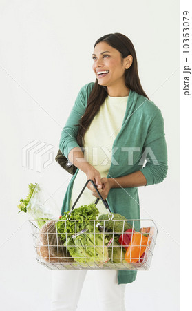 Studio shot of woman holding shopping basket with vegetables 10363079
