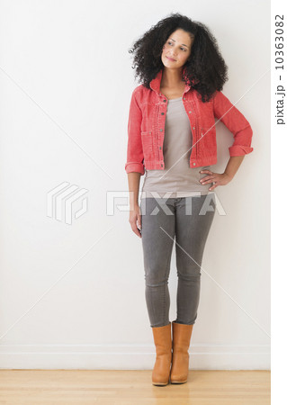 Portrait of smiling mid adult woman standing against wall 10363082