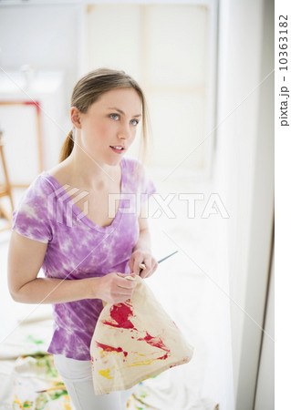 Female artist looking at painting in studio 10363182