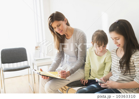 Woman and girls (4-5,8-9) in waiting room 10363310
