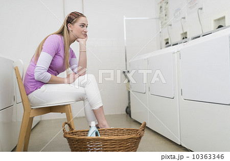 Woman waiting in laundromat 10363346
