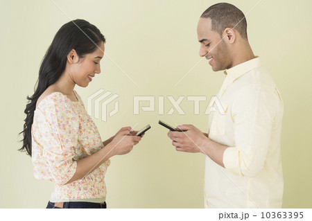 Young couple sending text messages simultaneously 10363395