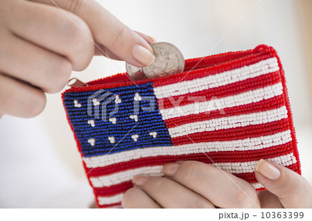 Woman holding coins and purse with american flag on it 10363399
