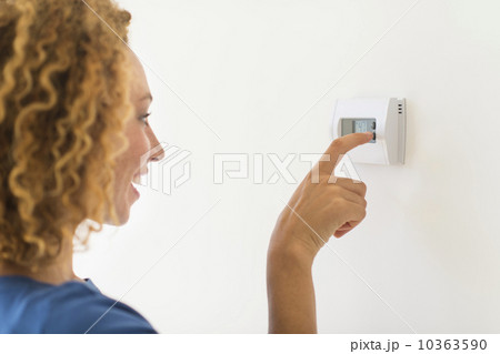 Young woman setting air conditioning 10363590