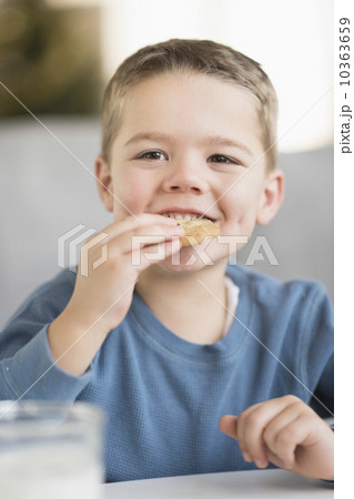 Boy (4-5) eating cookie 10363659