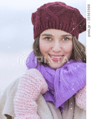 Portrait of young woman wearing knit hat, gloves and scarf 10363986